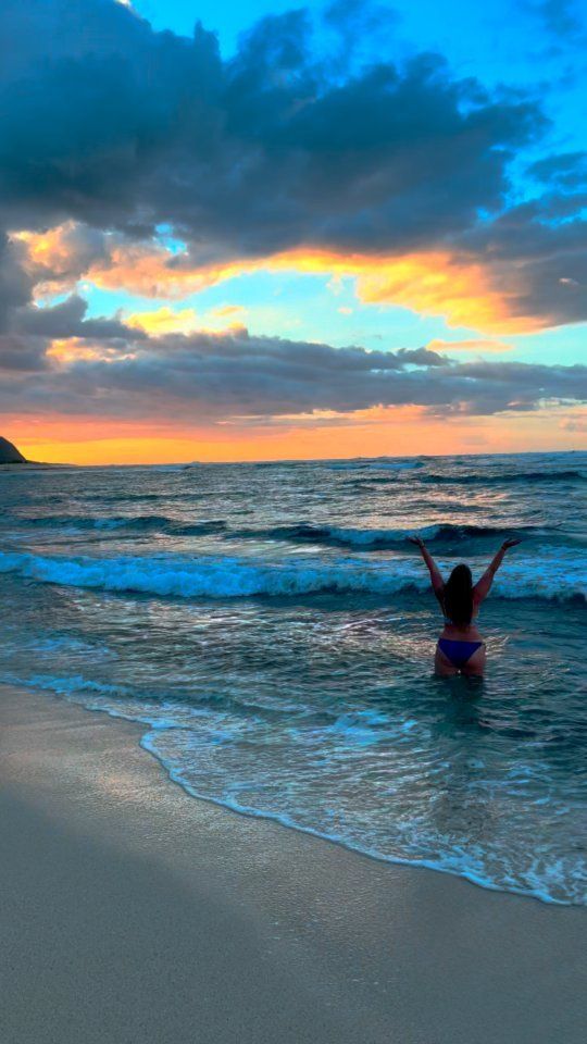 Laura jumping in the ocean in Hawaii